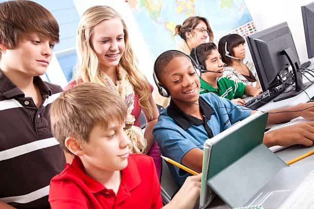A group of children in a classroom using computers.